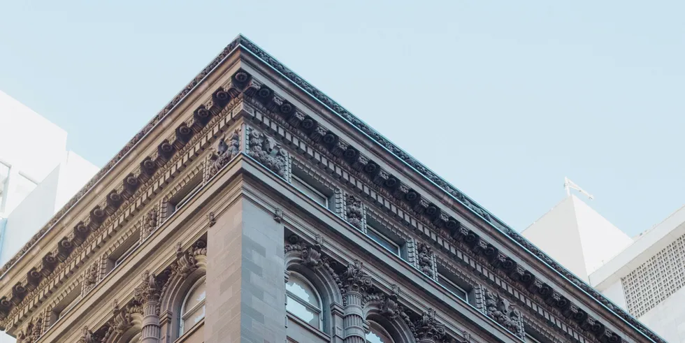 Corner of a historic stone building against a blue sky
